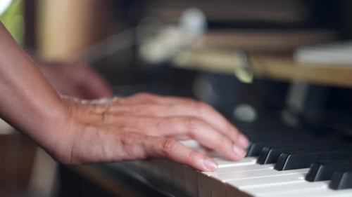 Close up of two hands playing a piano keyboard