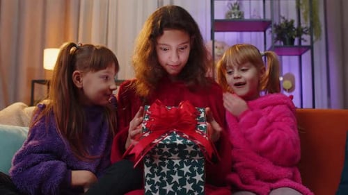 Three Girls Opening Birthday Gift with Excitement