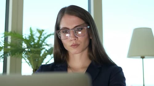 Female Business Person Working on Laptop Computer Desk in City Office