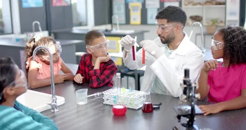 In a school laboratory, a group of students watches intently