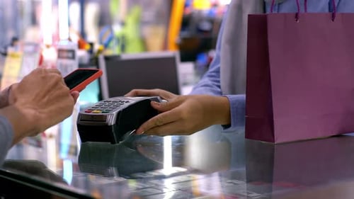 Asiatischer Muslim, der ein Handy zur Bezahlung benutzt 06