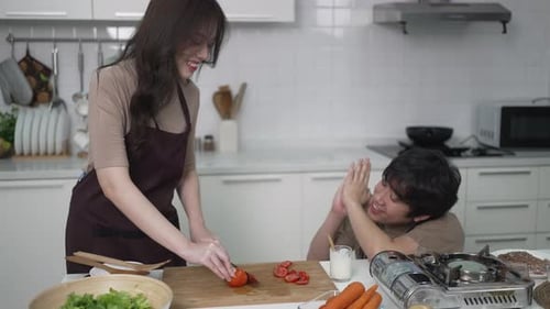 Smiling Woman Cooking with Friend in Bright Kitchen