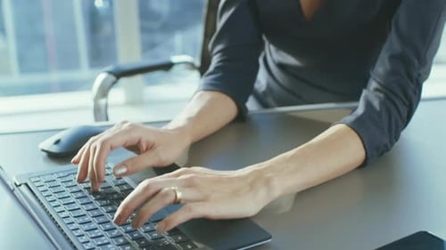 Ascending Portrait Shot of Attractive Successful Businesswoman Working on a Laptop in Her Office wi