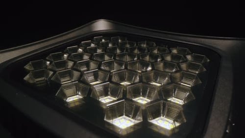 Lichtprojektor mit geometrischem Muster im dunklen Studio