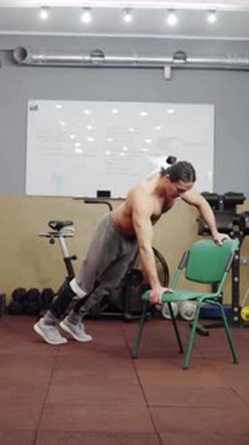 Man Doing Push Ups on Chair at Gym