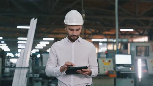 Modern digital tablet. Man is working in the modern factory.