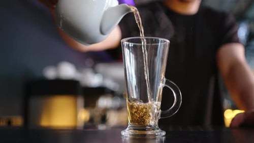 Bartender Poured Hot Tea Into a Glass on the Bar Counter in a Cafe Closeup