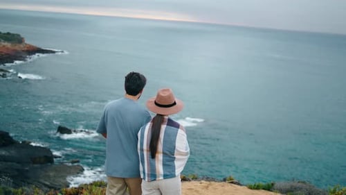 Romantic Young Couple Walking to Beautiful Sea Shore Back View. Relaxed Tourists