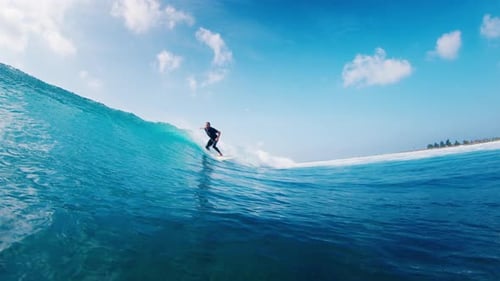 Man Surfs Ocean Wave in the Maldives