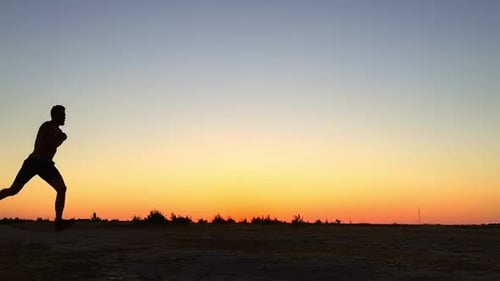 Man Silhouette Leaping During Dramatic Sunset