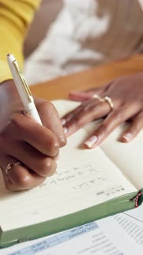 Woman Writes To Do List in Notebook at Desk