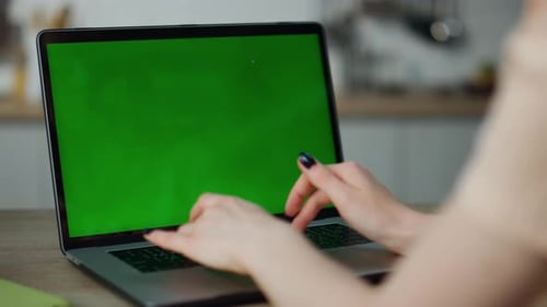 Unknown Woman Hands Typing on Green Screen Laptop Sitting at Table Close
