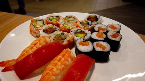 Wild salmon and tuna rotating on an assorted plate closeup on a white plate rotating at a Chinese Ja