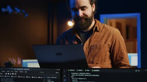 Remote IT Support Worker Standing in Home Office Programming on Laptop