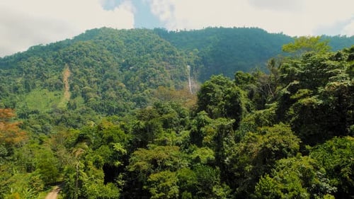 Distant lush green rainforest peaks and Diamante waterfall in Costa Rica