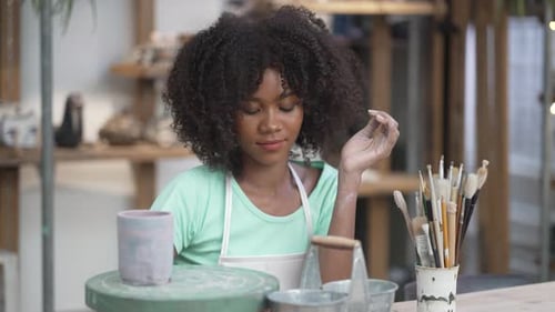 Young women is making earthenware at workshop.