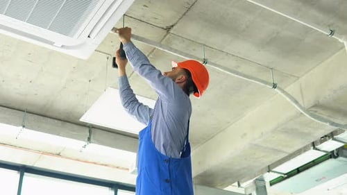 Technician Worker Installs Air Conditioning System and Heat Recovery System at Office