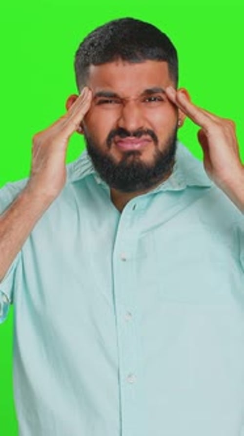 Man with Headache Massaging Temples on Green Screen