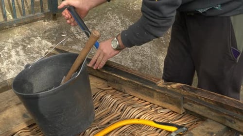A man
fixing a wooden sleight on Madeira at the top station. Catching a nail.