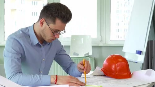Focused Architect Meticulously Drafting Building Plans