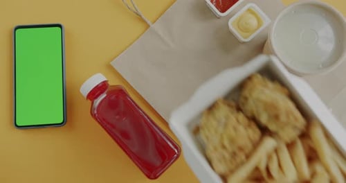 Top View of Hand Putting Delivered Lunch Fries Meat and Sauce Next to Green Screen Chroma Key