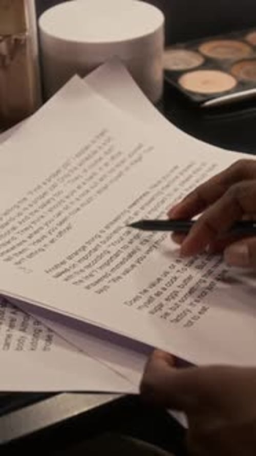 Person Holding Script and a Pen Close Up