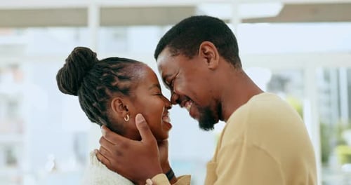 Young Couple Smiling and Embracing Indoors
