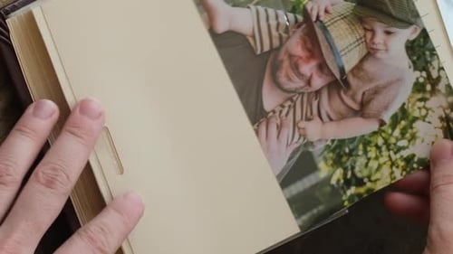 Vídeo vertical con las manos insertando una foto impresa en un álbum de fotos familiar