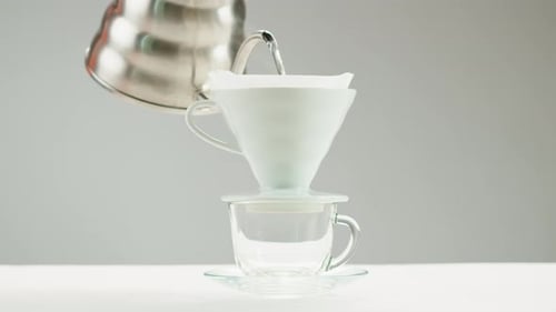 Water Pouring into Coffee Filter Over Clear Cup