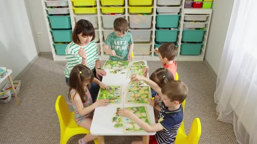 Children Put Together a Puzzle Using a Fishing Rod with a Magnet