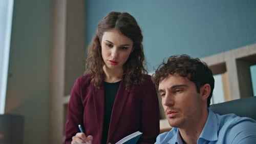 Auszubildender schreibt Mentorenanweisungen im Copybook Stehender Büroplatz hautnah