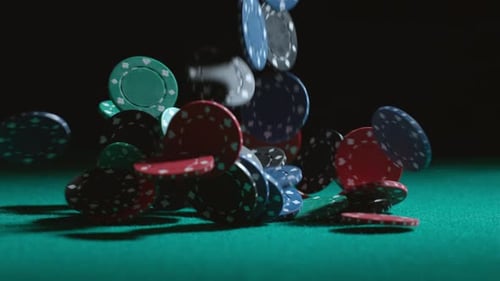 Casino Chips Falling onto a Green Felt Table