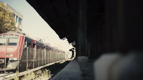 Altes Eisenbahnlager durch LKW-Kamerabewegung enthüllt, während ein Zug mit niedriger Geschwindigkeit vorbeifährt