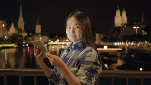 Young Asian Woman Using Smart Phone Tablet In the City Streets