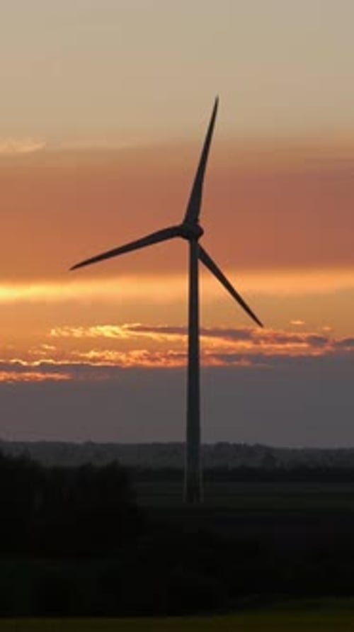 Wind Turbine Silhouetted Against Warm Sky Gradient