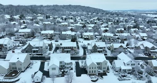 Modern American homes in USA covered in winter snow. Aerial view. United States residential communit