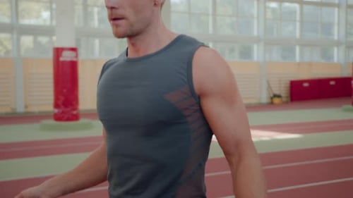 Muscular Man Exercising with Jump Rope Indoors