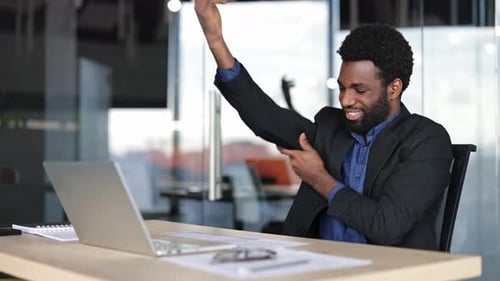 Businessman Massaging His Wrist and Arm Due to Pain at Office Desk