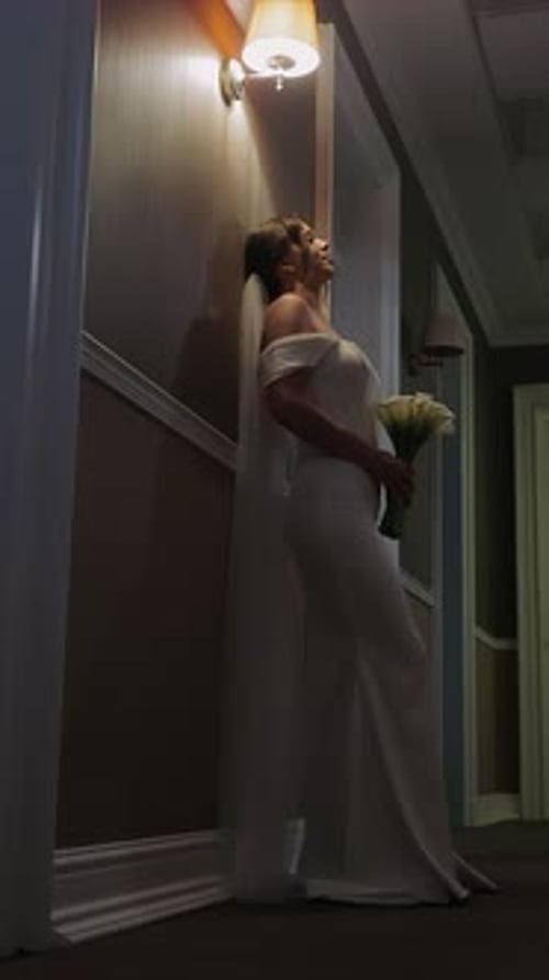 The Bride on Her Wedding Day in an Elegant Wedding Dress in the Hotel Corridor