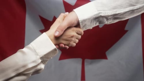 Business Handshake in Front of Canadian Flag