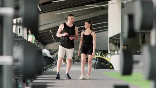 Man and Woman Walking in a Gym Together