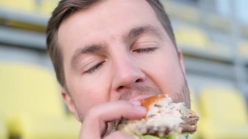 Closeup of Businessman Eating Hamburger During Lunch Break Harmful Street Food