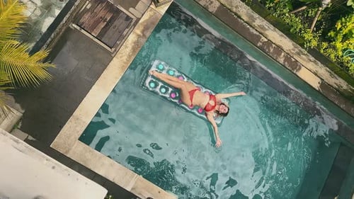 Top View Portrait of Young Woman Lying on an Inflatable Air Mattress