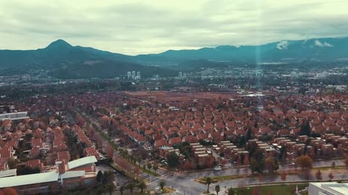 Fliegen in einem Viertel in den Vororten von Santiago mit blauen Bergen im Hintergrund.4K