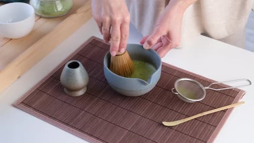 Woman Preparing Matcha Green Tea with Whisk
