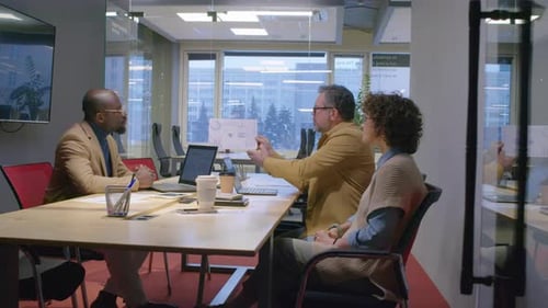 Männlicher Manager präsentiert Projektergebnisse bei einem Treffen vor verschiedenen Kollegen