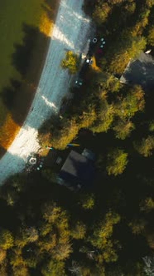Kayaks and beach chairs along forested lakeshore — top-down