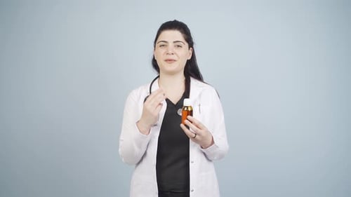 Female Doctor Holding Medicine Bottle in Studio