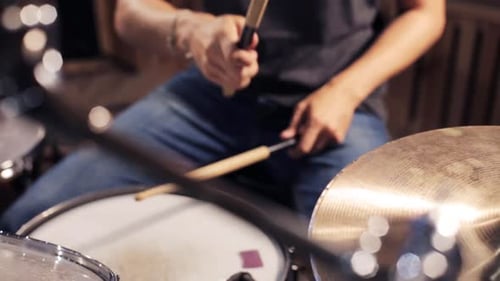 Drummer plays drum kit in music studio
