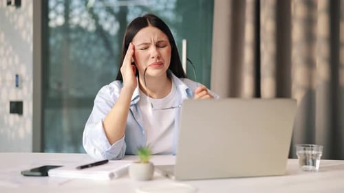Woman Working at Desk Having Headache and Eye Strain